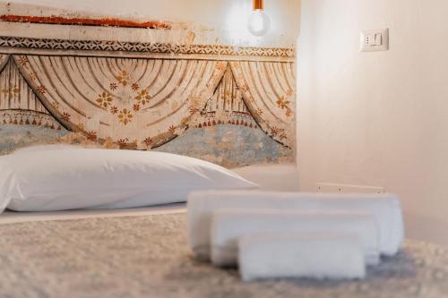 a bedroom with a bed with a headboard at Le Antiche Dimore di Cadia in Ugento