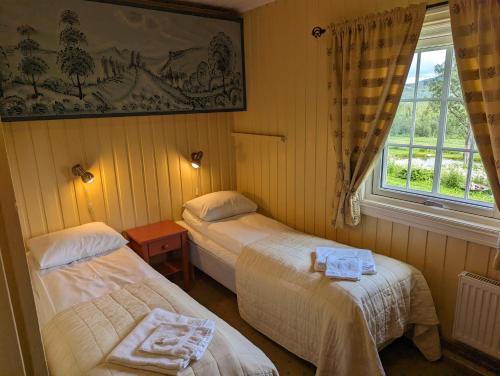 a room with two beds and a window at Grønolen Fjellgard in Beitostøl