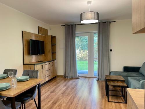 a living room with a table and a couch at Apartamenty MarSyl in Jastrzębia Góra