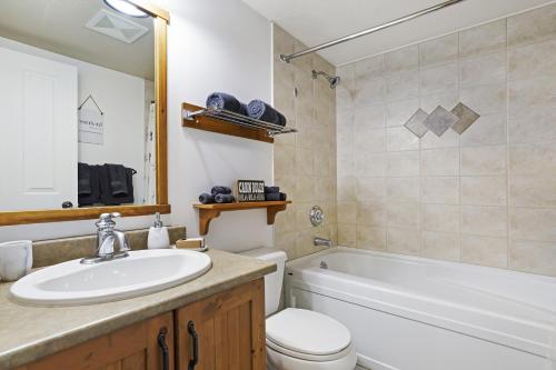 ein Badezimmer mit einem Waschbecken, einer Badewanne und einem WC in der Unterkunft Perfect Ski or Bike in-out Hot Tub Pool in Panorama