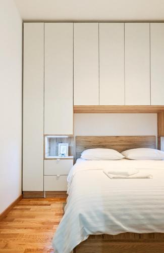 Schlafzimmer mit einem großen Bett und weißen Schränken in der Unterkunft Apartman Una in Kragujevac