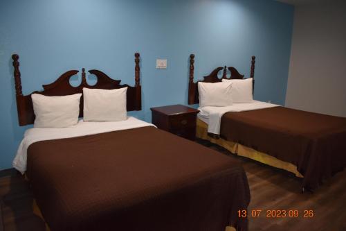 2 camas en una habitación con paredes azules en Executive Inn NEWLEY RENOVATED, en Baker