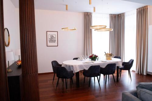 een eetkamer met een witte tafel en stoelen bij Botanique Suites AirBnB, Antwerp in Antwerpen