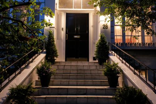 a black door on a house with stairs at Dawson Place, Juliette's Bed and Breakfast in London