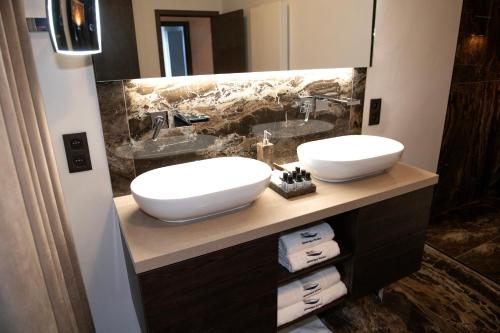 a bathroom with two sinks and a large mirror at Botanique Suites AirBnB, Antwerp in Antwerp
