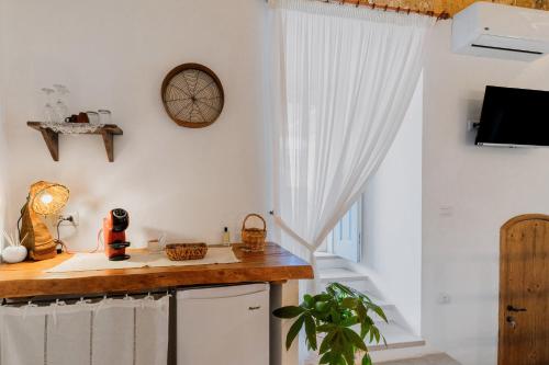 a kitchen with white walls and a wooden counter at Le Antiche Dimore di Cadia in Ugento