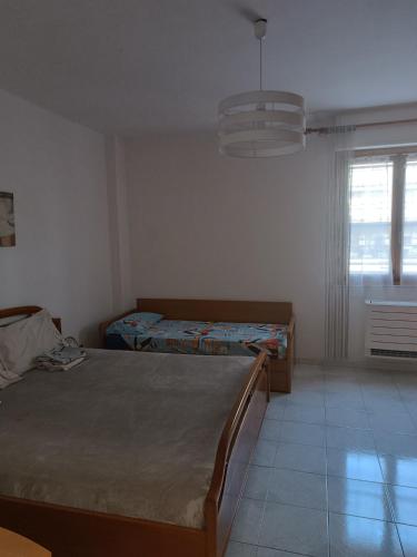 sypialnia z dwoma łóżkami i oknem w obiekcie Casa graziosa con ampio cortile per i tuoi momenti all'aperto w mieście Alghero