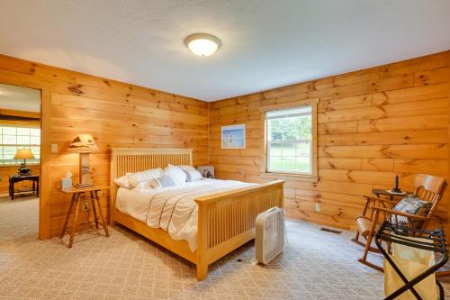 1 dormitorio con 1 cama en una habitación con paredes de madera en Serene Mountain Retreat on 40 Acres with Fire Pit! 