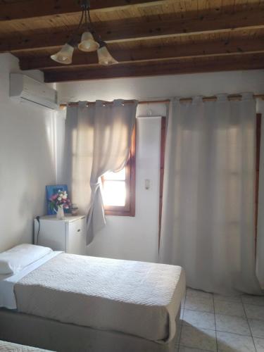 a bedroom with a bed and a window at Notos Rooms in Loutro