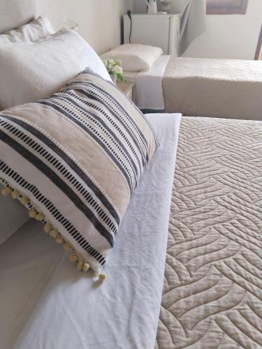 a bed with a pillow sitting on top of it at Notos Rooms in Loutro