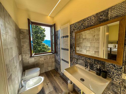 a bathroom with a sink and a toilet and a mirror at Agriturismo Dandelion in Città della Pieve