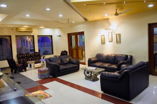 a living room with leather couches and a table at Shree Ji Resort in Nāthdwāra