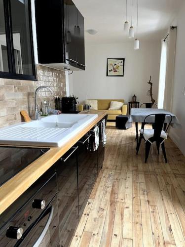- une cuisine avec un évier et une table dans l'établissement Cocon romantique à Vichy, à Vichy