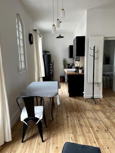 un salon avec une table et une cuisine dans l'établissement Cocon romantique à Vichy, à Vichy