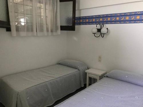 プラヤ・デアロにあるApartamento en Platja d'Aroのベッドルーム1室(ベッド2台、テーブル、鏡付)