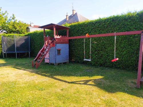 un parque infantil en un patio junto a un seto en Apartmán na Rybářské, en Zábřeh