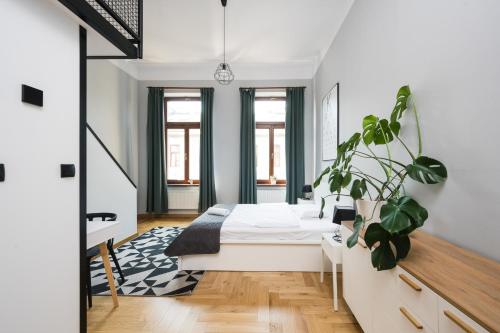 a bedroom with a bed and a potted plant at Beautiful apartment, great location, Old Town & Kazimierz in Kraków
