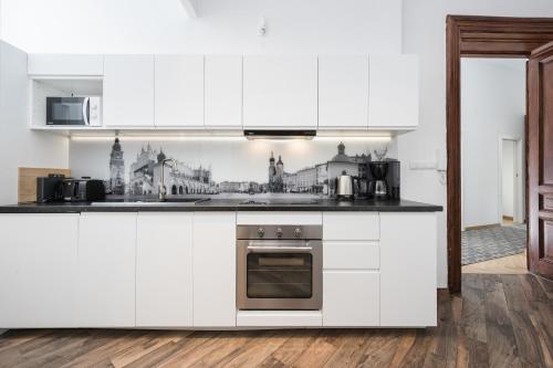 een keuken met witte kasten en een fornuis met oven bij Beautiful apartment, great location, Old Town & Kazimierz in Krakau