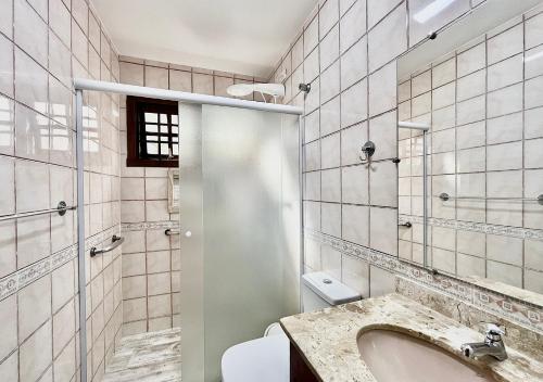 uma casa de banho com um lavatório, um WC e um espelho. em Casa de temporada estilo rústico - Litoral Norte de SP em São Sebastião
