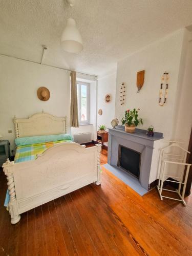 a bedroom with a bed and a fireplace at Auberge du Crabère in Melles