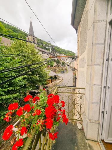 a balcony with red flowers on a building at Auberge du Crabère in Melles