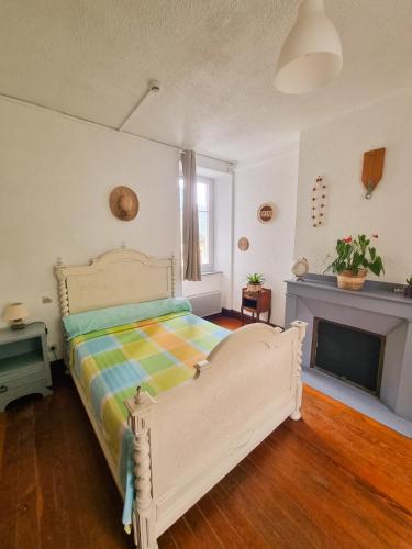 a bedroom with a bed with a colorful blanket at Auberge du Crabère in Melles