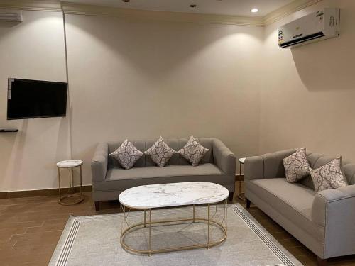 a living room with a couch and a table at شهد الثانية للشقق المخدومة in Al ‘Abābīd