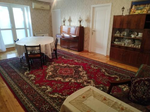 a living room with a table and a rug at Friends Guest House in Ganja