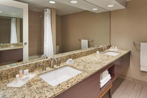 a bathroom with two sinks and a large mirror at Holiday Inn - Executive Center-Columbia Mall, an IHG Hotel in Columbia