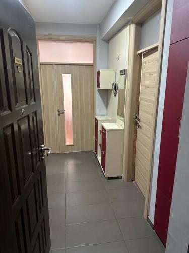 a corridor of a room with a door and a kitchen at Dada Lux in Kumanovo