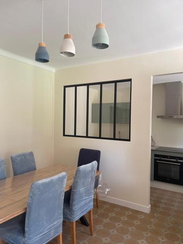 a dining room with a wooden table and blue chairs at Maison Colonel Teyssier in Albi