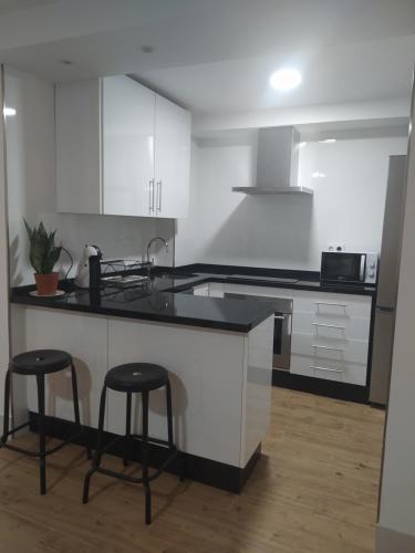 a kitchen with a counter and two bar stools at SANTO ANGEL 7 in Seville