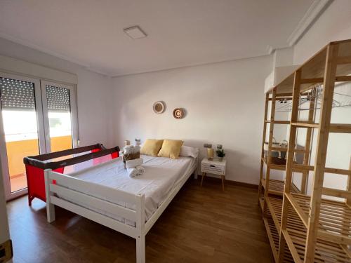 a white bedroom with a bed and a shelf at La Pita in Almería