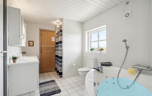 y baño con bañera, aseo y lavamanos. en Nice Home In Hvide Sande With Sauna, en Bjerregård