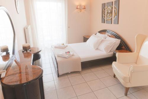 a hotel room with a bed and a chair at Mangata Apartment in Preveza