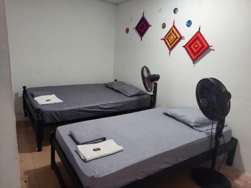 - 2 lits dans une chambre avec drapeaux sur le mur dans l'établissement apto #5 cómodo y acogedor en lugar estratégico, à Ríohacha