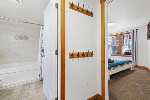 a bathroom with a shower and a bed in a room at Perfect Ski or Bike in-out Hot Tub Pool in Panorama