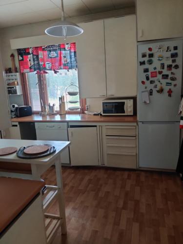 a kitchen with a refrigerator and a table at Nina`s GuestHouse, Jämsä City, 160 m2, Include x2 Himos Ski Pass in Jämsä