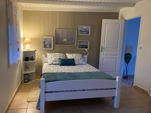 een slaapkamer met een wit bed in een kamer bij T2 Ti Joe Au cœur de Guadeloupe in Lamentin