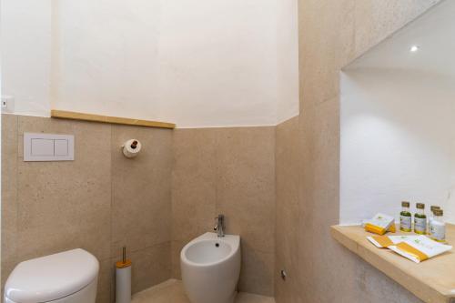 a bathroom with a white toilet and a sink at Le Antiche Dimore di Cadia in Ugento