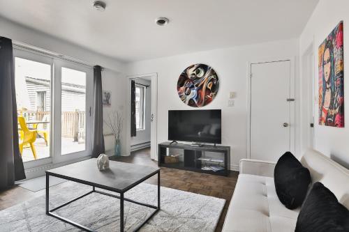 uma sala de estar com um sofá branco e uma televisão em FREE PARKING and CENTRAL location em Montreal
