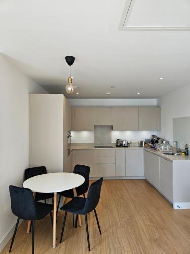 a kitchen with a table and chairs in a room at Santina Apartments in Croydon