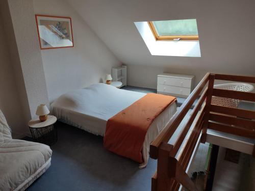 ein Schlafzimmer mit einem Bett und eine Treppe mit einem Fenster in der Unterkunft Duplex Le Reflet du Lac in Malbuisson