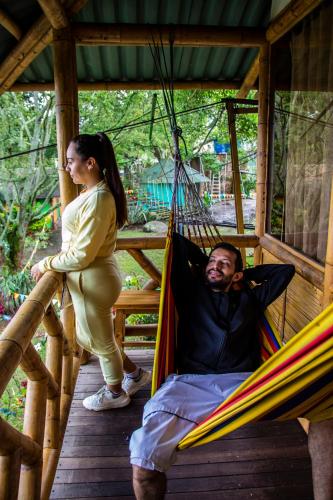 a woman standing next to a man in a hammock at CASA DEL ÁRBOL, Romántico, Piscina, en Chinauta, el mejor clima in El Michú