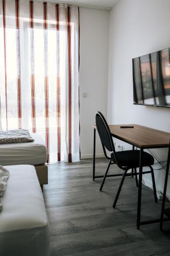 a room with a desk and a bed and a table at Dill Apartments Stederdorf in Peine