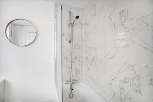 a white bathroom with a shower with a mirror at Delightful Home in Seaham, Sleeps 4 in Seaham