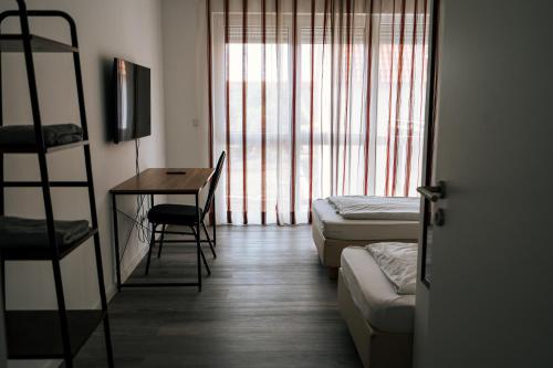 um quarto com 2 camas, uma secretária e uma escada em Dill Apartments Stederdorf em Peine