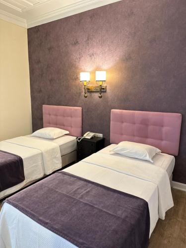 two beds in a hotel room with pink accents at Hotel Joao Padeiro in Aveiro