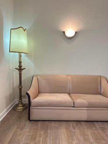 a couch in a living room with a lamp at Hotel Joao Padeiro in Aveiro