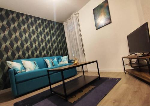 een woonkamer met een blauwe bank en een tafel bij chazi and cosy in Toulouse